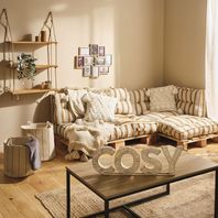Salon aux teintes claires avec canapé en palettes et déco "cosy"