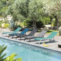 plusieurs transats colorés alignés au bort d'une piscine