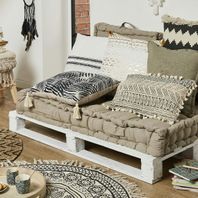 Canapé en palettes blanches avec coussins ethniques beige, blanc et noir