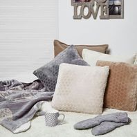 Coussins doux et clairs, tasse et chaussettes épaisses